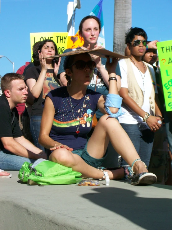 there are many people holding signs and sitting together