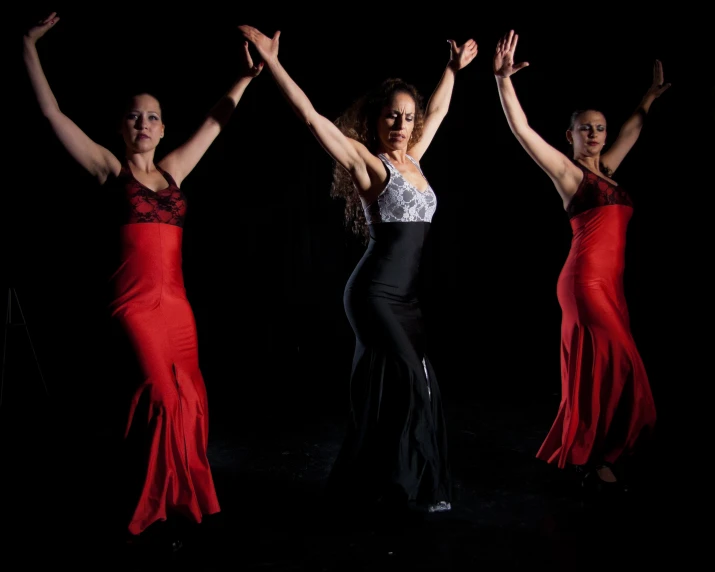 four people in dresses are doing a dance routine