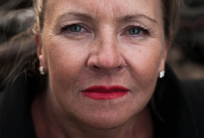 a closeup of an older woman with red lipstick