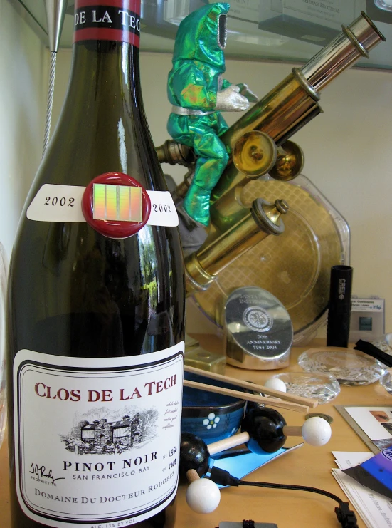 a bottle of wine is displayed near a watch