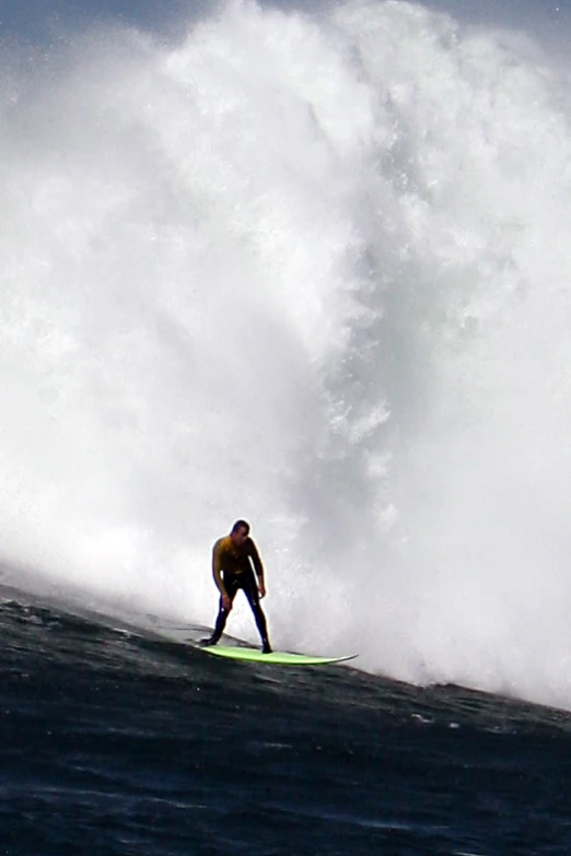 a man on a surfboard riding a big wave