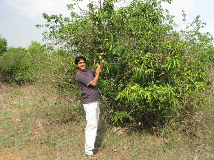 a boy standing in the middle of a field holding an object