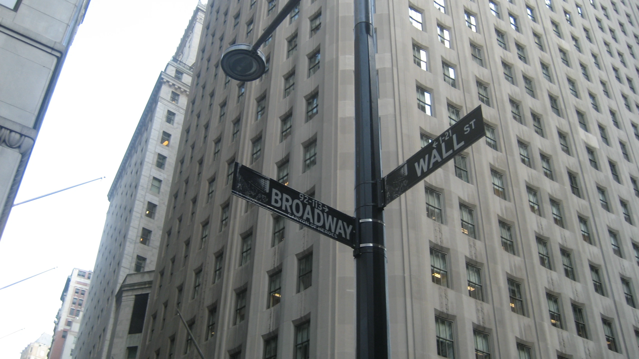 street signs are seen in front of a large building