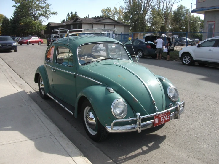 a old vw beetle parked in a street