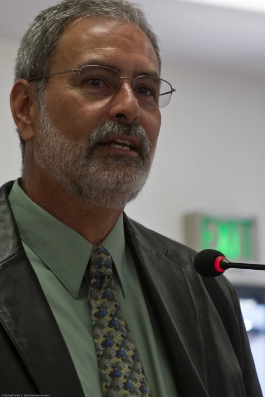 an old man with a beard wearing glasses and a green shirt