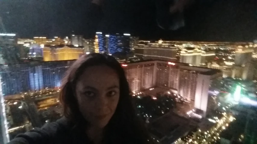 a woman taking a selfie on the side of a high rise