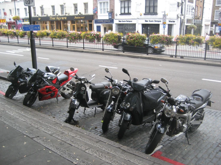 three motorcycles are lined up on a sidewalk
