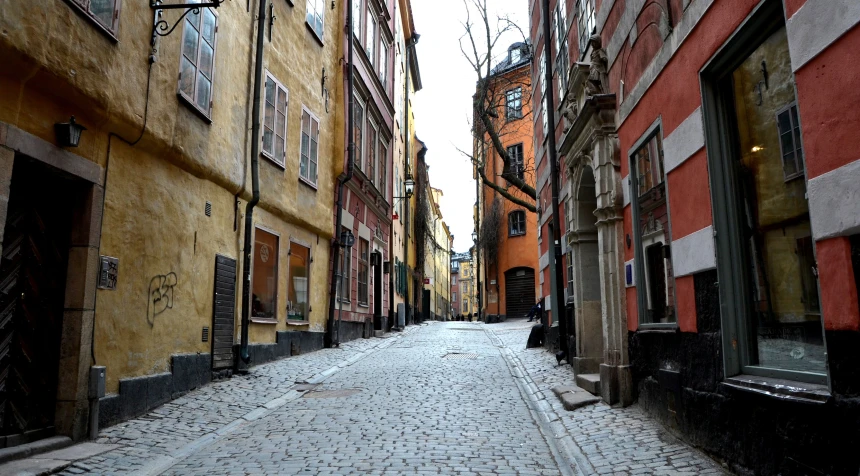 a narrow city street lined with stone buildings