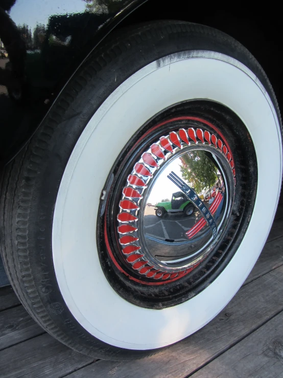 the reflection of an automobile's tire on some wooden boards