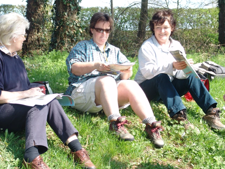 three people sitting and talking in the park