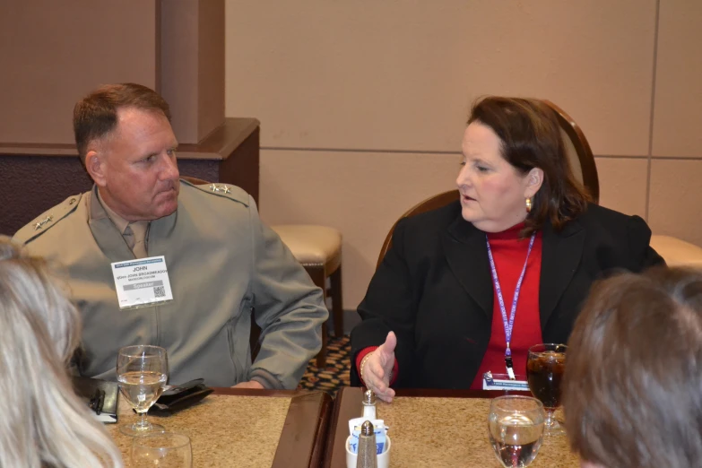 two military officers sitting at a table with other patrons