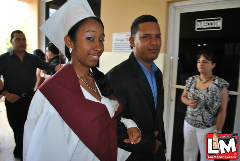 a couple walking down the hall in graduation attire