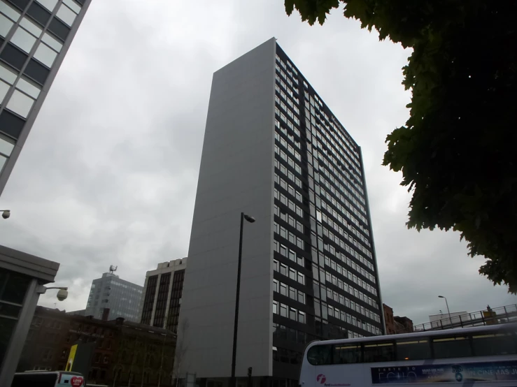 two buses that are near some buildings