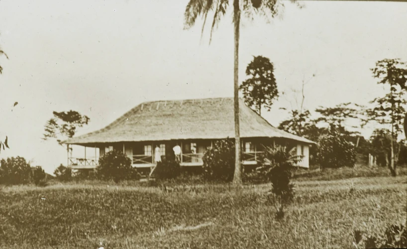 old black and white po of a person standing in front of a house