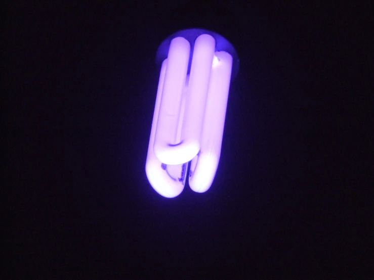 purple light tubes in the dark with one tube illuminated