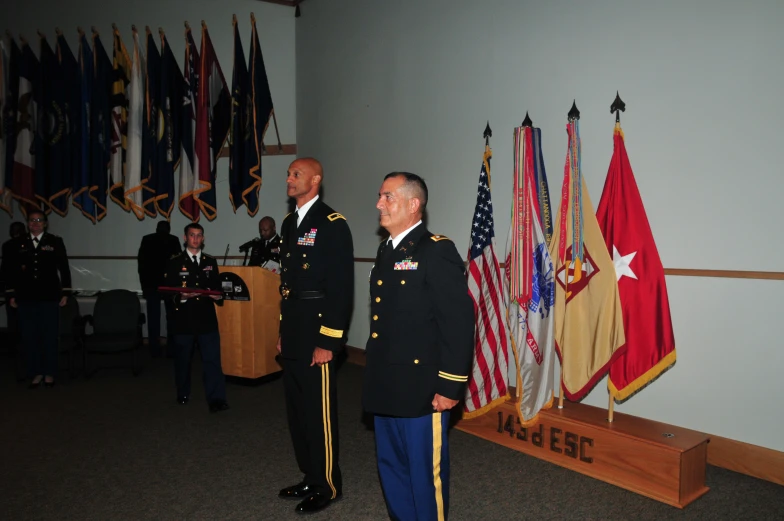 two people in uniforms talking at a podium