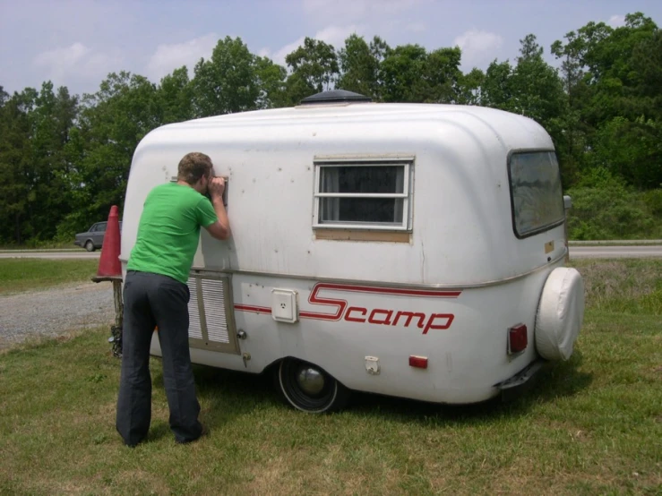 two people loading up an old camper