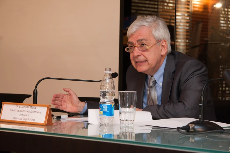 a person sitting at a table holding a plaque in front of him