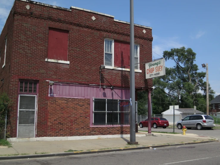 a red brick building with two cars parked in front of it