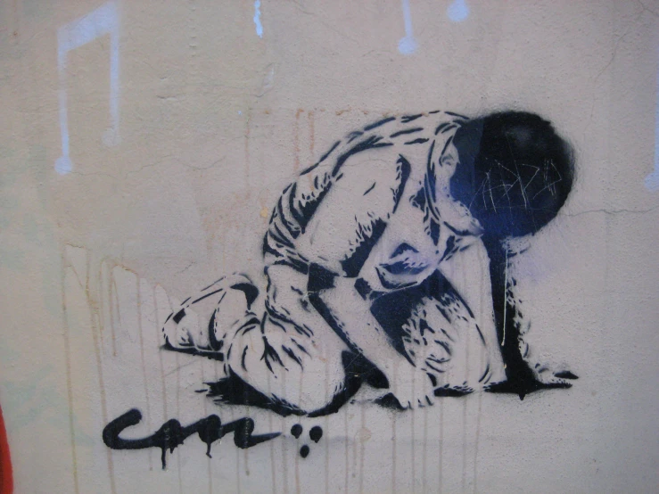 graffiti of a person bent down on the ground