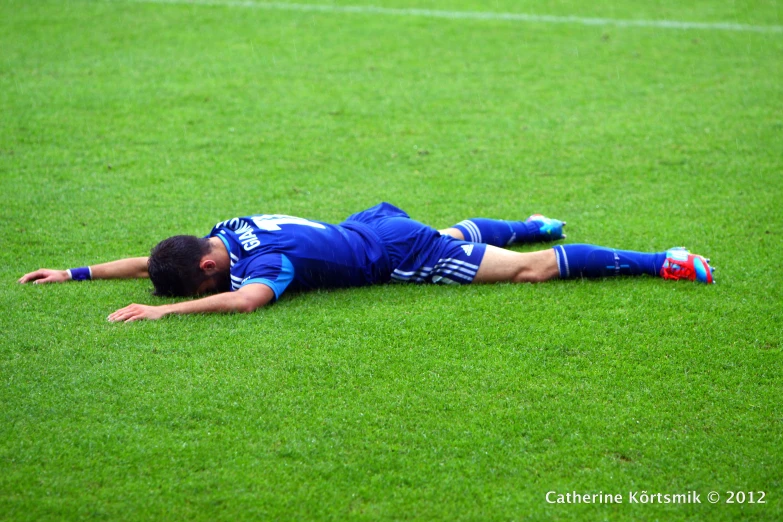 there is a man laying on the soccer field