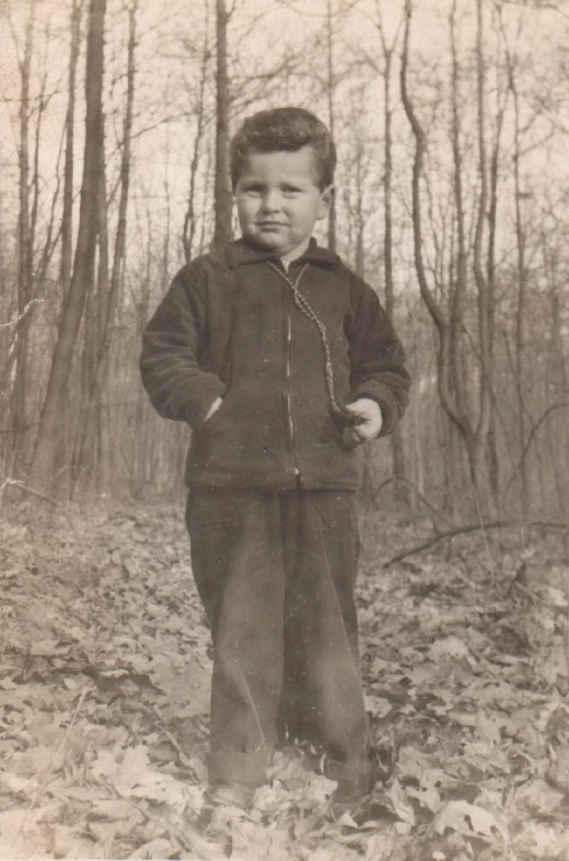 a  is standing in the leaves in an old picture
