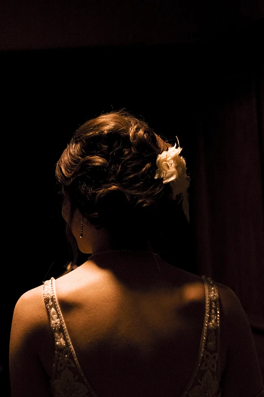 a woman with her back turned looking at the wall