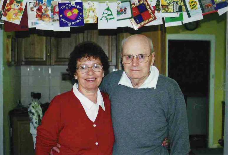 the elderly man and woman are posing together