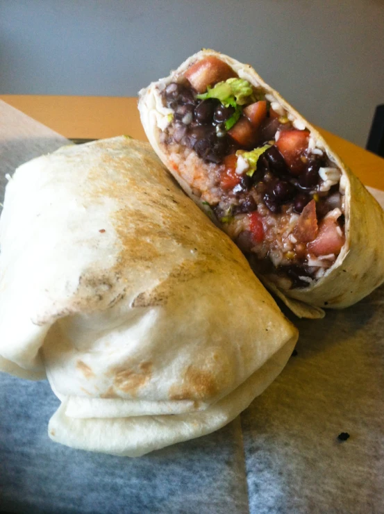 two burritos next to each other on a counter