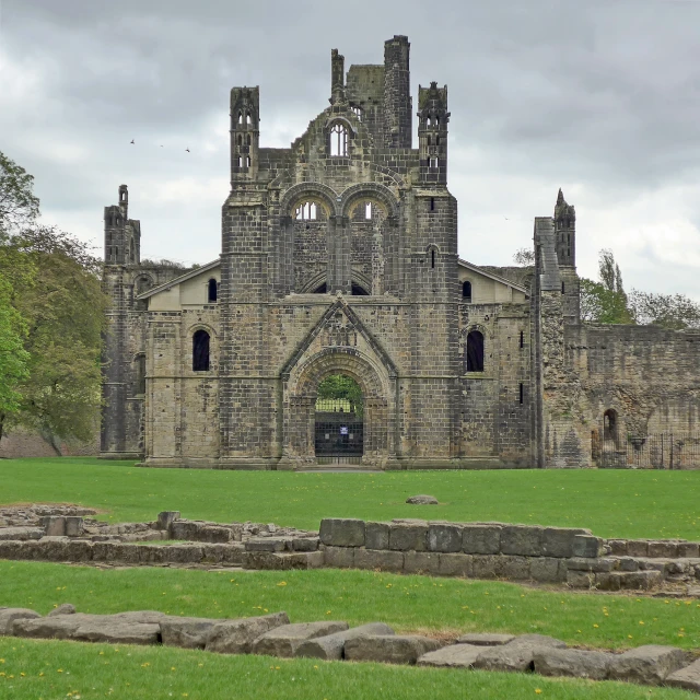 a cathedral sitting in the middle of a green field