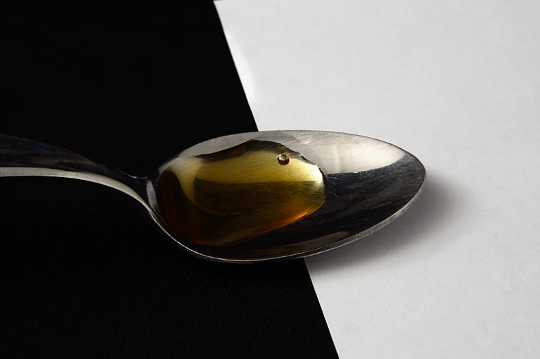 a spoon sitting on top of a table holding some food