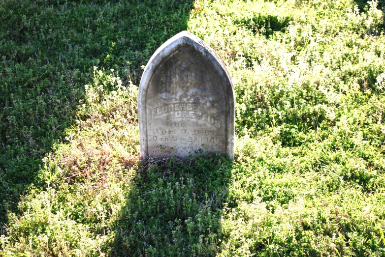 an old cemetery stone grave in grassy field