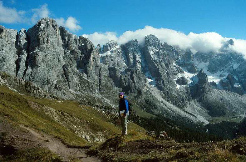 a person hiking uphill with a snowy mountain in the background