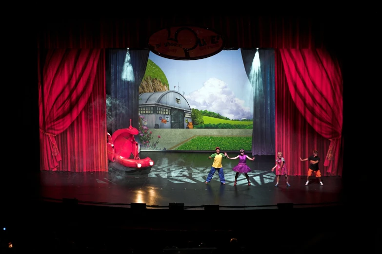 a group of children in front of a stage performing a show