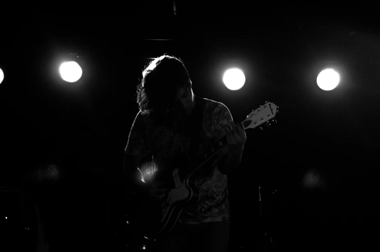 a person is standing in front of a stage playing guitar