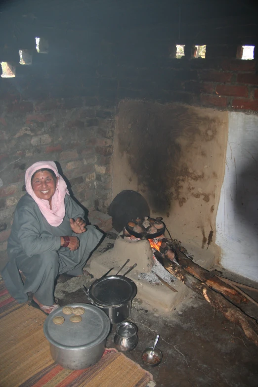 a woman sitting on the floor with some cooking items