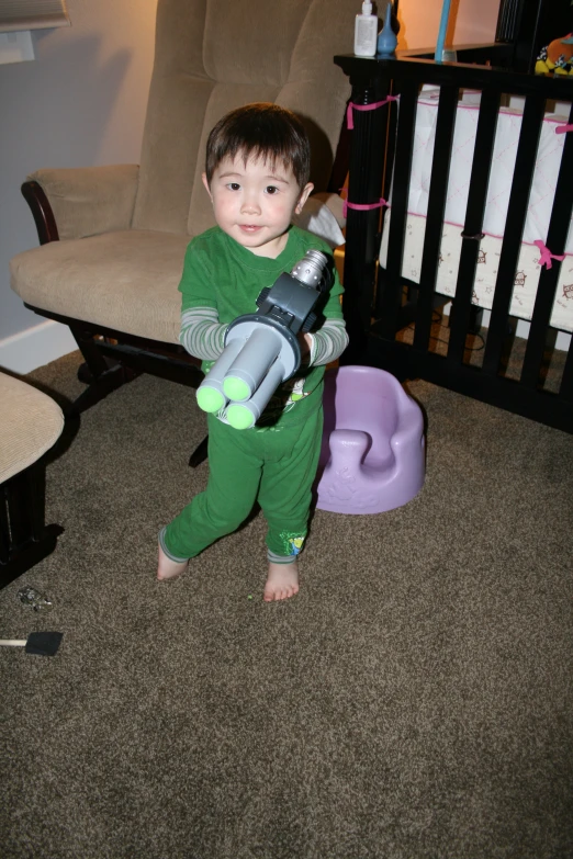 a baby holding a toy camera in his arms