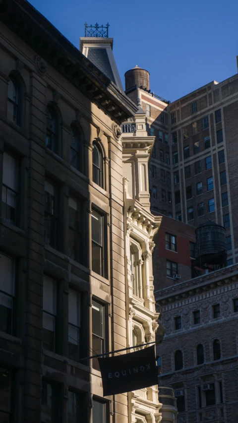 a tall building next to other buildings on the street