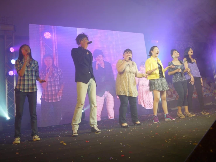 a crowd of people standing on top of a stage