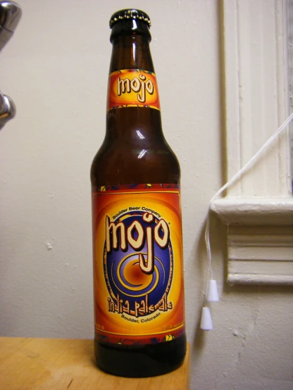 an open bottle of beer on a wooden counter