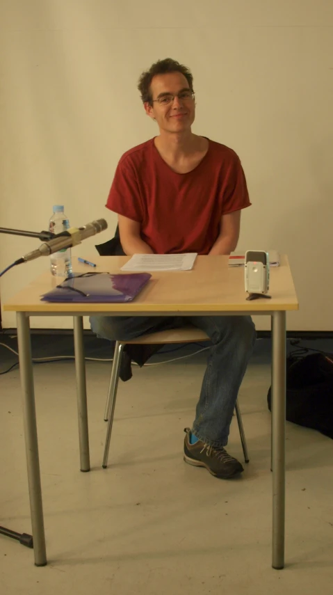 a man sitting at a table near a microphone