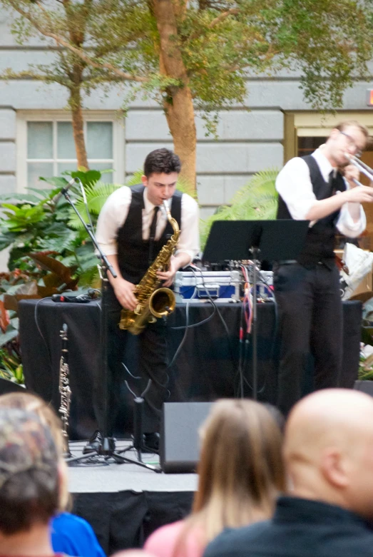 band playing on outdoor stage while people watch