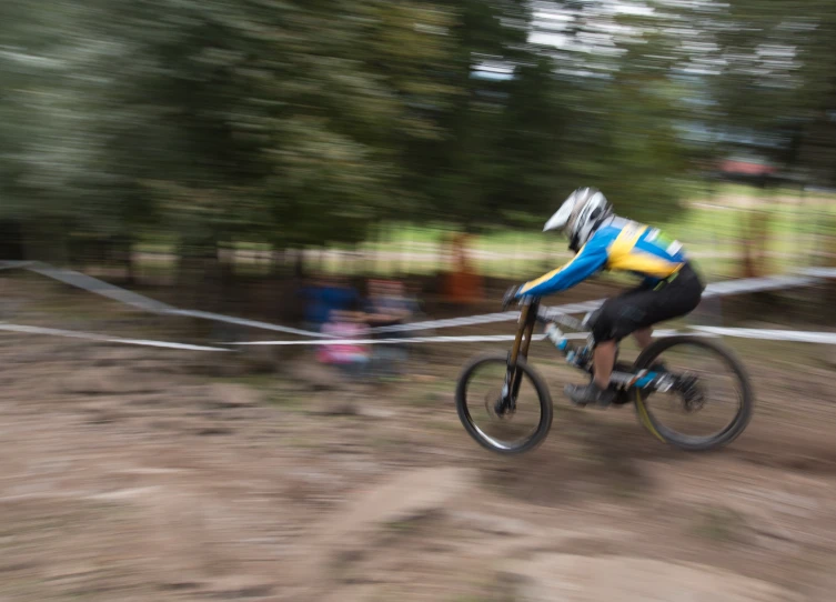 the bicyclist is racing on the trails during the day