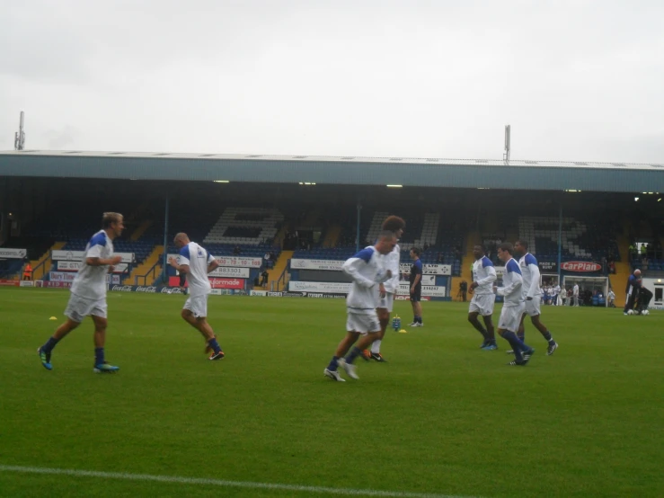 several young men playing soccer in front of a large building