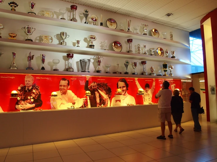 a restaurant counter has wine glasses and people are milling about