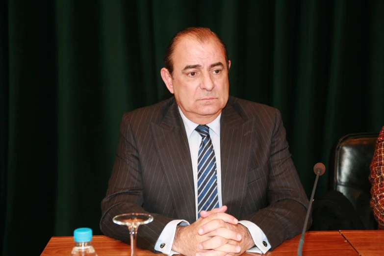 a man sitting at a table wearing a suit