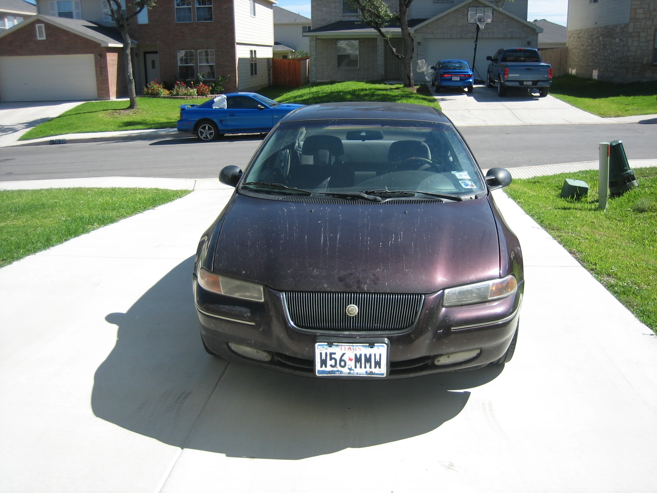 a brown car parked in front of a house