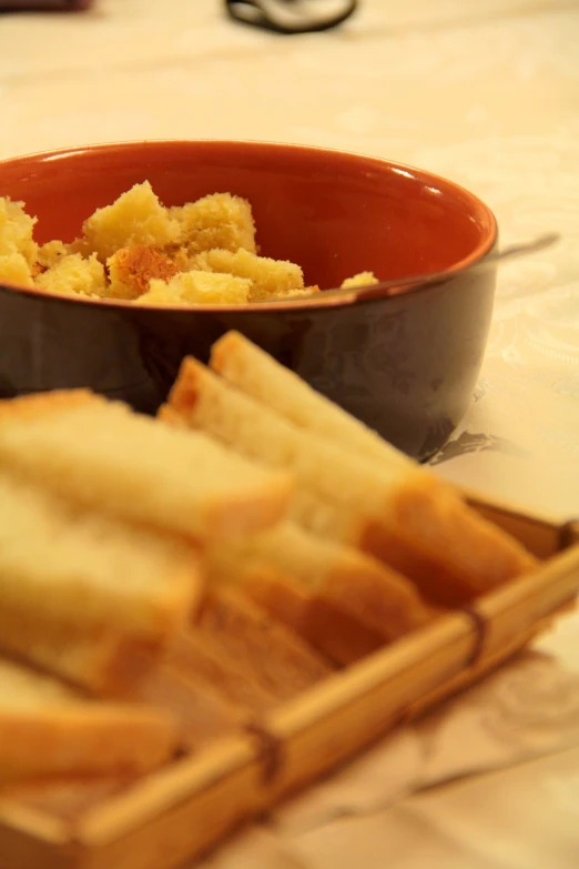 some bread slices and a bowl are on the table