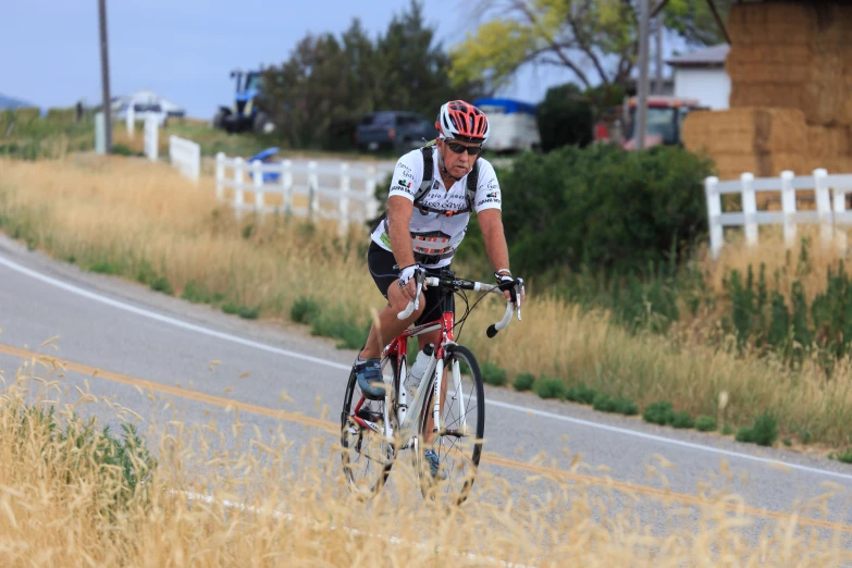 a person riding on a bike along a country road