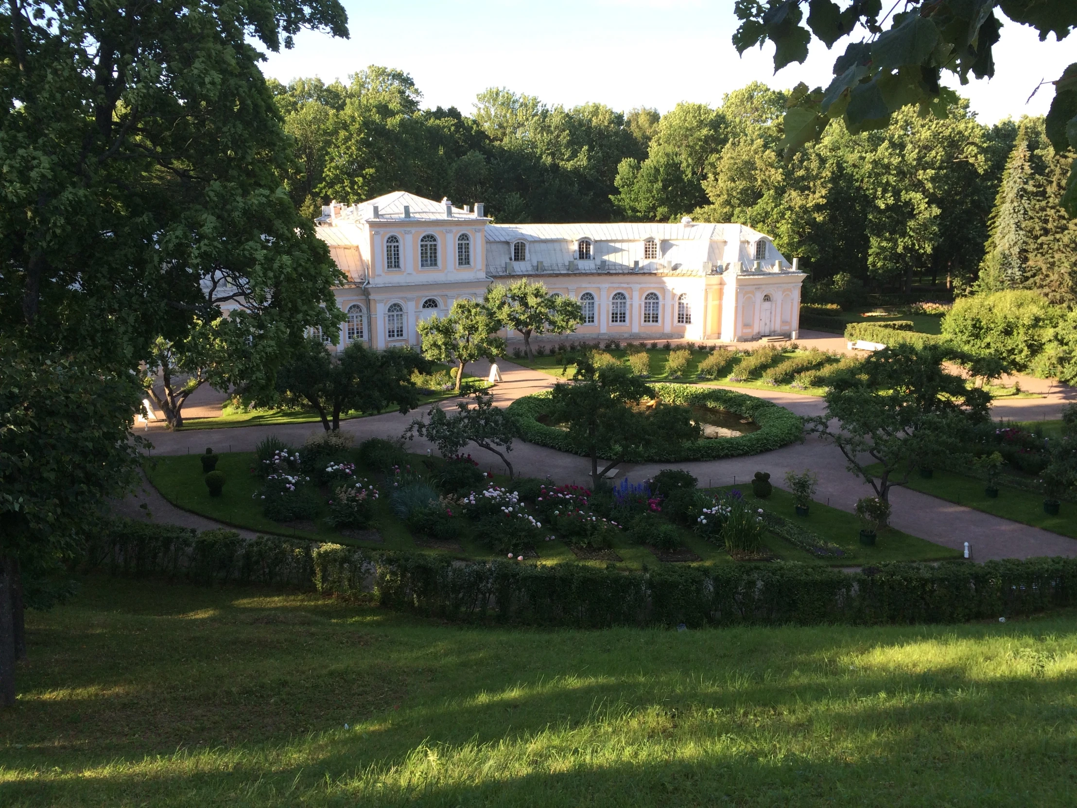 a house with lush green yard next to lots of trees